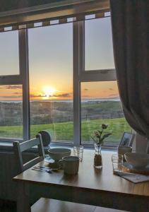 拉斯诺拉Sea Crest B&B Rossnowlagh的一张桌子,从窗口可欣赏到日落美景
