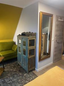 米德尔哈根Hotel & Gasthof Zur Linde的客厅配有绿色沙发和镜子