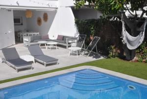 锡切斯Miramar Sitges的一个带椅子的庭院和一个游泳池