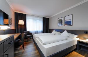 不莱梅ATLANTIC Hotel Landgut Horn的配有一张床和一张书桌的酒店客房