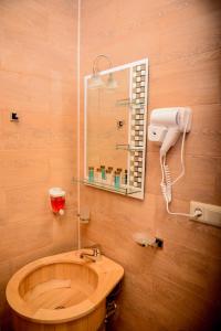 茨卡尔图博Hotel Samta的一间带木制水槽和镜子的浴室