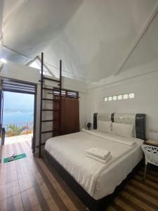 图克图克Vandu's View Guest house & Restaurant的一间带大床的卧室和一个阳台