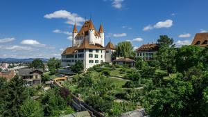 图恩Jewel in the center of Thun's old Town的一座树冠茂密的山顶上的城堡