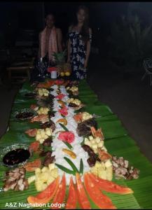 BacunganA&Z Nagtabon Lodge的绿毯上的长桌食物