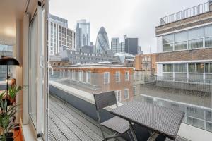 伦敦Kula London - Tower Hill的大楼内的阳台配有桌椅