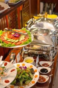 宁平Tam Coc Condelux Boutique Hotel & Travel的餐桌上的自助餐,包括盘子