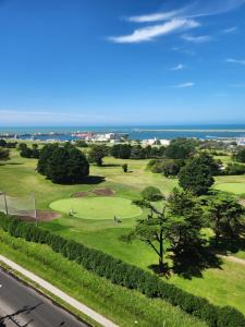 马德普拉塔Departamento Playa Grande Alem Golf的享有高尔夫球场的海景