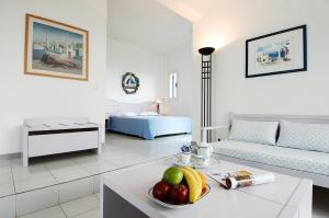 卡普萨利奥埃尔索尔酒店的客厅配有带一碗水果的桌子