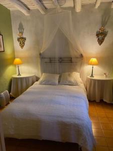 阿拉哈尔Casa El Collado的卧室配有白色的床和两张桌子