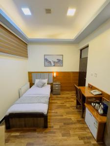 喀布尔Khyber Hotel的酒店客房配有一张床、一张书桌和一张书桌。