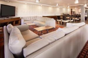 萨尔蒂约喜来登萨尔蒂福朋酒店的客厅配有白色沙发和平面电视。