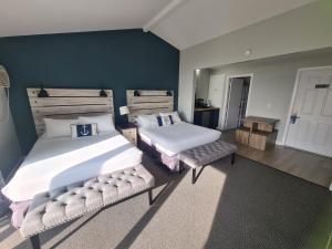 BoothbaySmuggler's Cove Inn的一间卧室设有两张床和蓝色的墙壁
