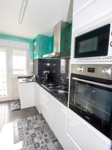 比纳罗斯Playa el Clot - Vinaròs的厨房配有白色橱柜和炉灶烤箱。