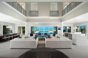 浮木村Sun Salutations villa的客厅配有白色家具,享有海景。