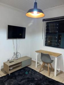 开普敦Rest Easy with 24/7 security的客厅配有书桌、电视和椅子