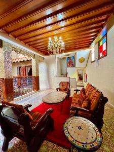 拉巴特Riad el wazzania的客厅配有皮革家具和吊灯。