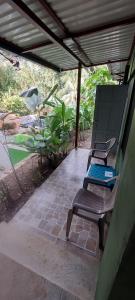 德雷克Corcovado & Drake Inn的两把椅子坐在屋顶下的庭院