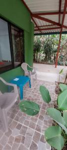 德雷克Corcovado & Drake Inn的一个带桌椅和绿色墙壁的庭院