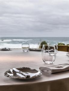 Barizo苍鹭旅馆的沙滩上一张桌子,上面有两杯和盘子