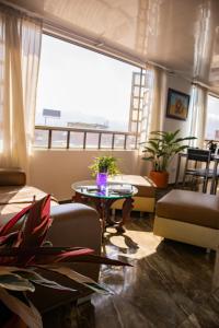 波哥大Encantador cómodo y confortable.的客厅设有桌子和大窗户