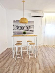 塞维利亚Evangelista59的厨房配有白色的桌子和凳子
