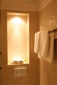 巴尼亚卢卡维多利亚别墅酒店的带淋浴、镜子和毛巾的浴室