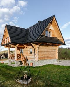 CicheChałpy Pod Ostryszem的屋顶上有一个黑色屋顶的房子