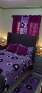 哈拉瓦科阿Maria e Nicola的一张带紫色棉被和枕头的床