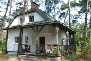 波别罗沃Domyletnie Pobierowo Duży dom 140m2 z działką的一座古老的房子,在树林里围着门廊