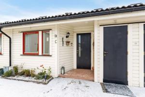 EidsvollCozy and central home near Oslo Gardermoen Airport的白色的房子,有黑色的门和窗户
