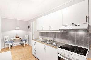 EidsvollCozy and central home near Oslo Gardermoen Airport的一间厨房,配有白色家电和桌椅