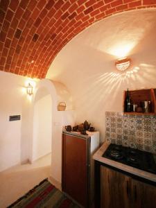 ChebbaDouira S+1的厨房配有炉灶和砖砌天花板