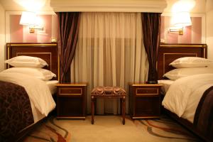 巴尼亚卢卡维多利亚别墅酒店的酒店客房,设有两张床和凳子