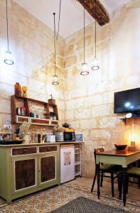 瓦莱塔Myrtle Suite - Valletta ground floor apartment的厨房配有桌子和电视。