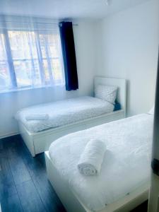 伦敦Comfortable and Cosy London Stay的两张床位于带窗户的房间内
