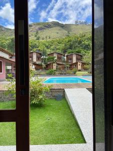 佩德拉阿祖尔Pousada Aracê的从带游泳池的房子门口可欣赏到风景
