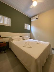 佩德拉阿祖尔Pousada Aracê的一间卧室配有一张带白色床单的大床
