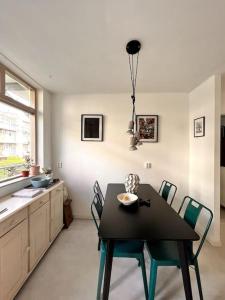 阿姆斯特丹Lovely, light and calm 1-bedroom apartment的一间用餐室,配有黑色的桌子和椅子