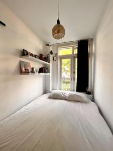 阿姆斯特丹Lovely, light and calm 1-bedroom apartment的卧室配有一张大白色床和窗户