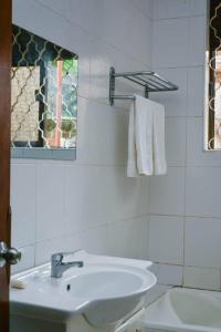 坎帕拉Naalya Motel的白色的浴室设有水槽和窗户。