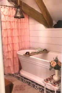 拿骚Its Day One I Do Bridal Dressing Suite的带浴缸和粉红色淋浴帘的浴室