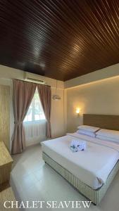 马六甲Lovita Tanjung Bidara Beach Resort的一间卧室设有两张床和木制天花板