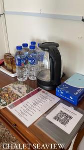 马六甲Lovita Tanjung Bidara Beach Resort的咖啡壶和桌子上的瓶装水