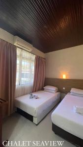 马六甲Lovita Tanjung Bidara Beach Resort的一间卧室设有两张床和窗户。