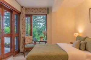 西姆拉Jais Cottage A Charming Hideaway的一间卧室设有一张床和一个窗口