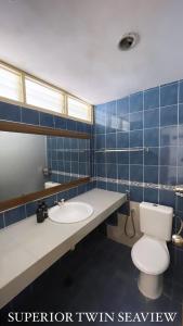 马六甲Lovita Tanjung Bidara Beach Resort的蓝色瓷砖浴室设有卫生间和水槽