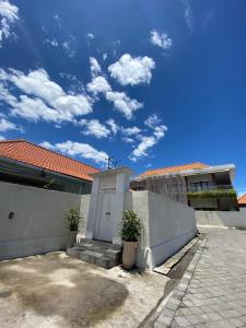 坎古The Jangkar Canggu Guesthouse & Villa的白色围栏和白色门的房子