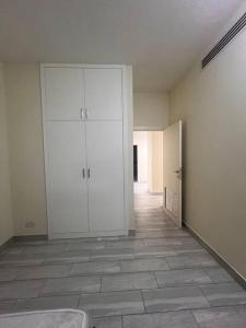 迪拜Deira Family Rooms的一间设有白色橱柜和瓷砖地板的客房