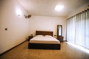 DankotuwaTharidu Hotel Dankotuwa的一间卧室设有一张床和一个大窗户