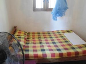 KatugastotaSUPER SUN HOMESTAY的一张带彩色毯子和窗户的床